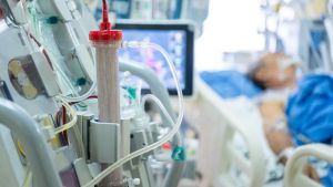 CRRT machine with ICU patient in the background