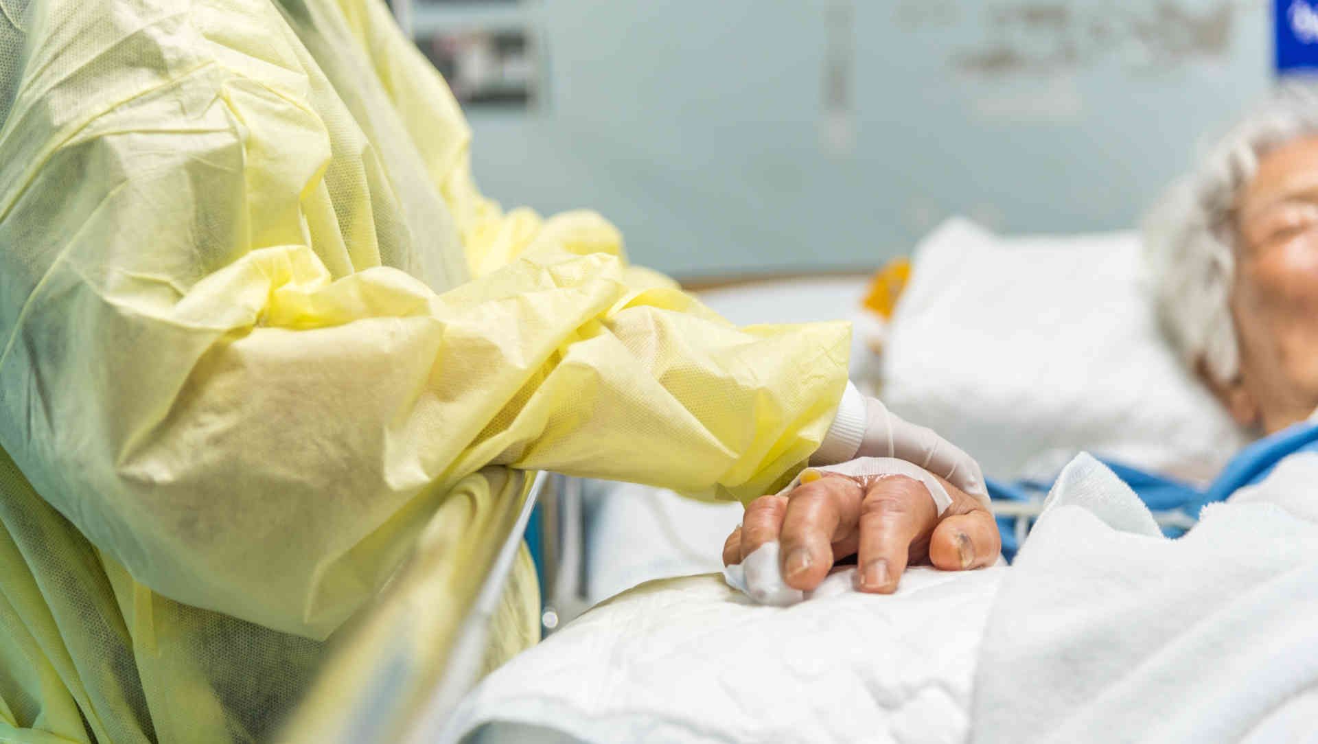 Nurse holding a patient's hand